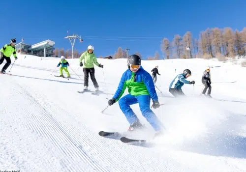 Ihr seht mehrere Personen beim Skifahren auf der Petzen im Winter.