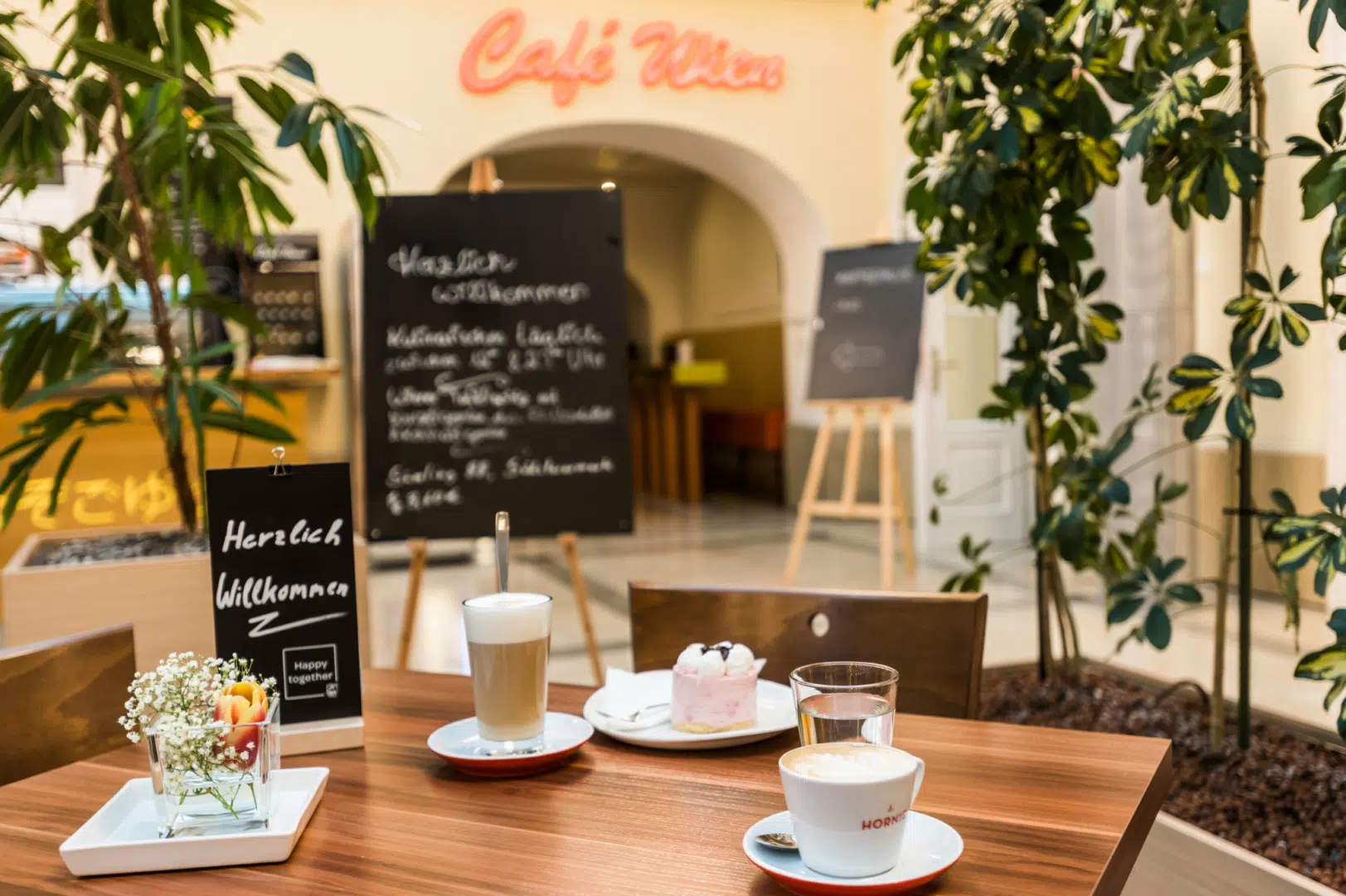 Ihr seht das gemütliche Wiener Café im JUFA Hotel Wien City mit Tischdeko. JUFA Hotels bietet erlebnisreichen Städtetrip für die ganze Familie und den idealen Platz für Ihr Seminar.