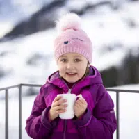 Mädchen mit Teetasse am Balkon vom JUFA Hotel Laterns