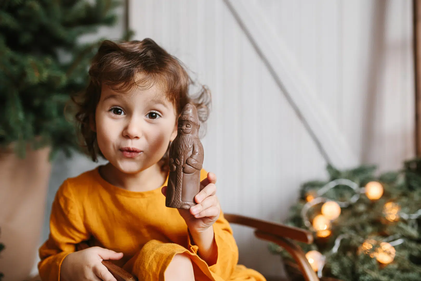 Ihr seht ein Mädchen mit einem Schoko-Nikolaus in der Hand. JUFA Hotels bietet erholsamen Familienurlaub und einen unvergesslichen Winterurlaub.