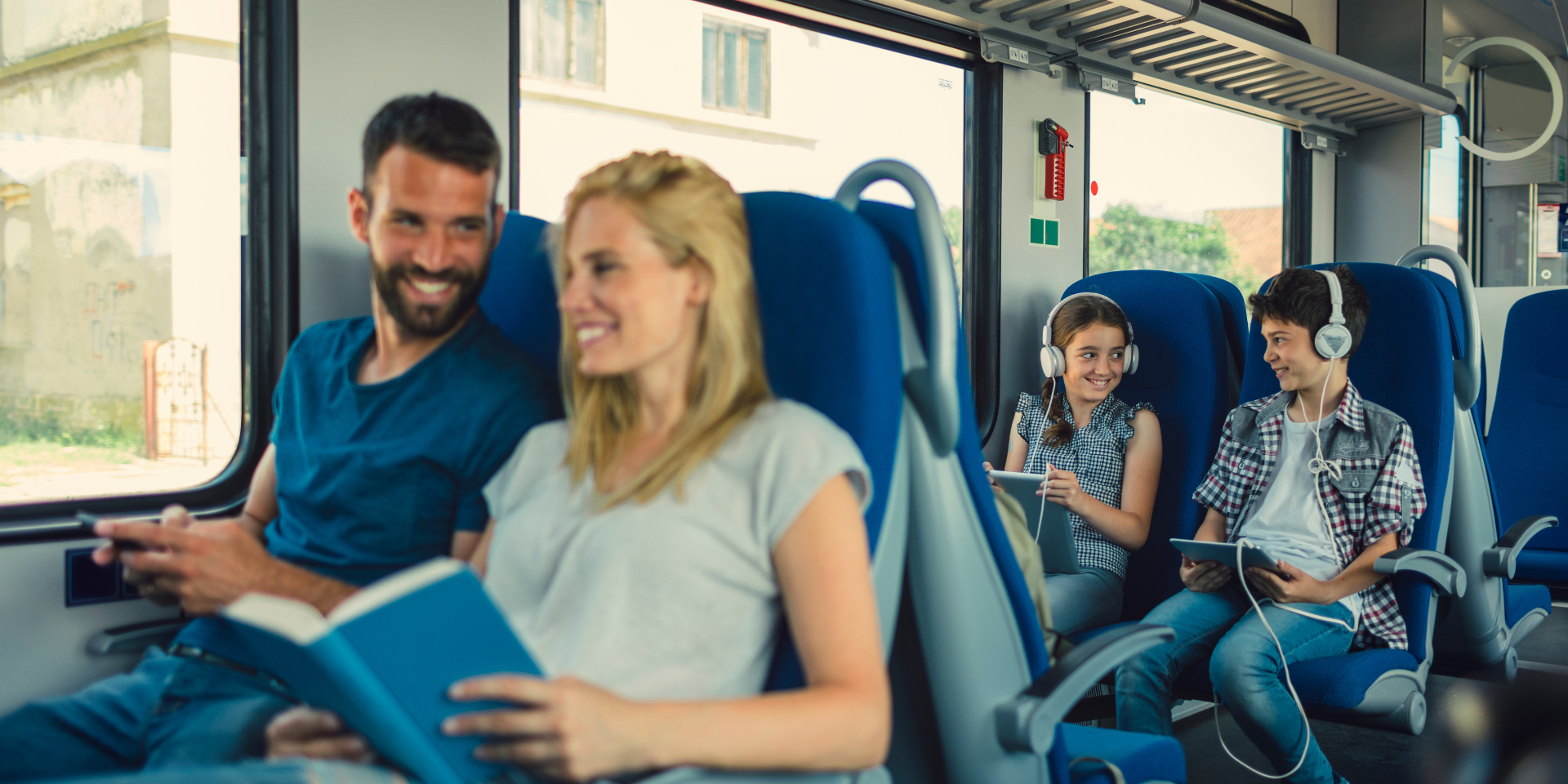 Familie sitzt im Zug auf der Reise in den Urlaub