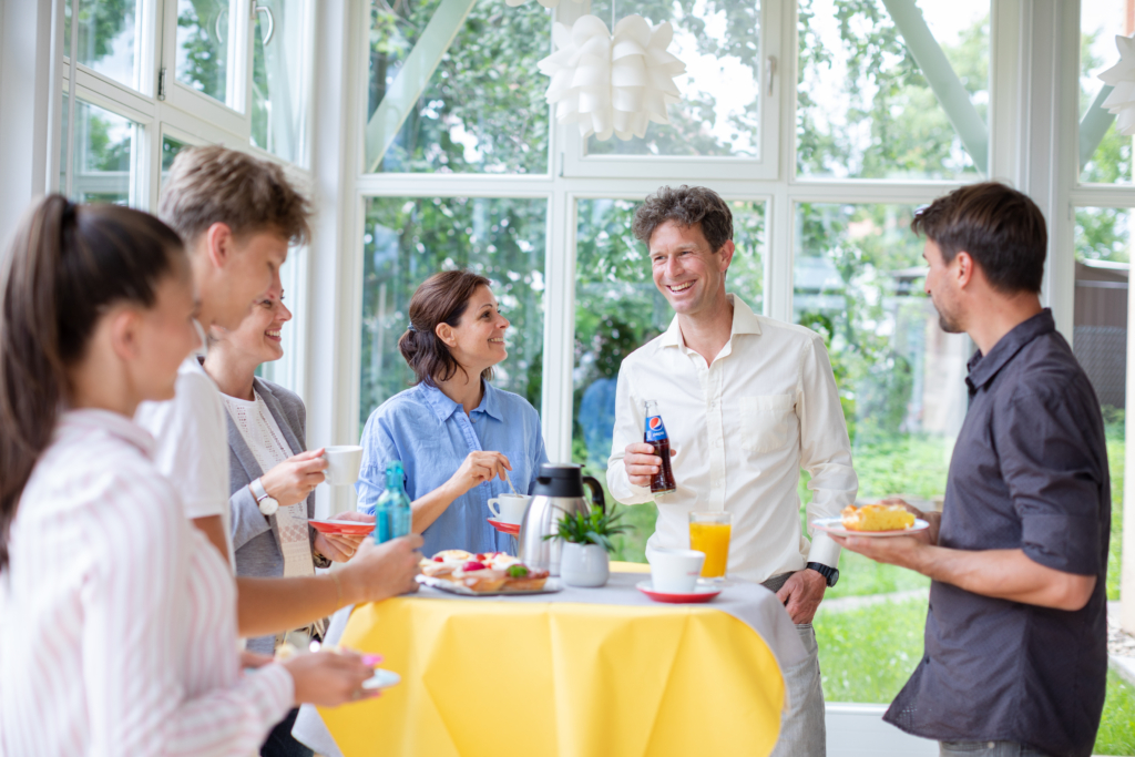 Sie sehen Meetingteilnehmer bei der Pause im Gespräch. JUFA Hotels, der Ort für kinderfreundlichen und erlebnisreichen Urlaub für die ganze Familie.