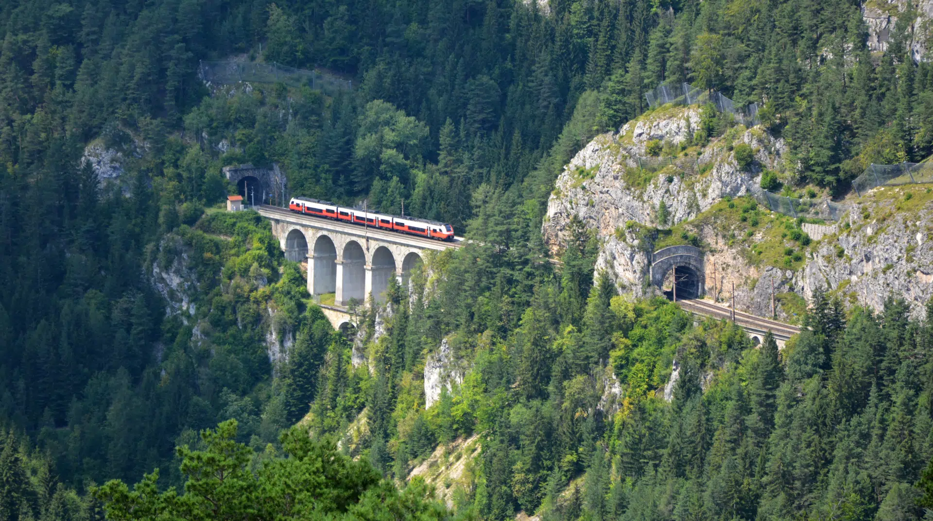 Ihr seht eine Brücke der Semmering-Bahn mit einem Zug.