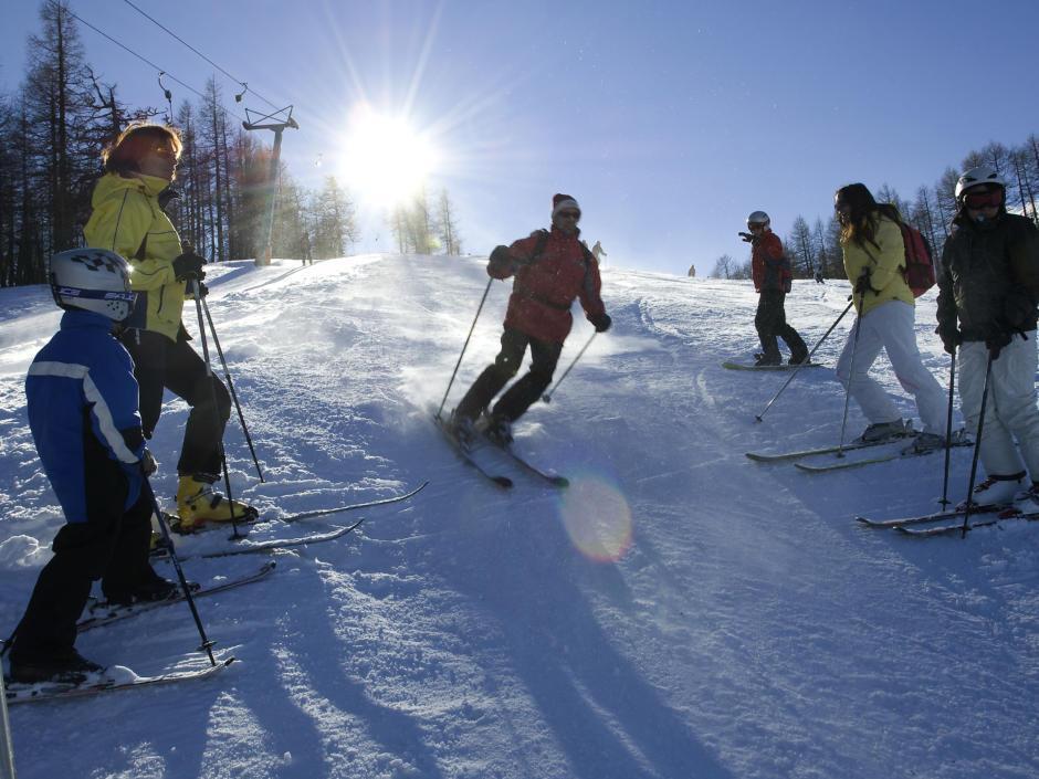 Sie sehen Skifahrer auf der Skipiste der Petzen im Winter. JUFA Hotels bietet erholsamen Familienurlaub und einen unvergesslichen Winterurlaub.