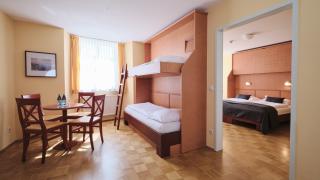 Sie sehen ein Zimmer mit Stockbett und Tisch im JUFA Hotel Meersburg